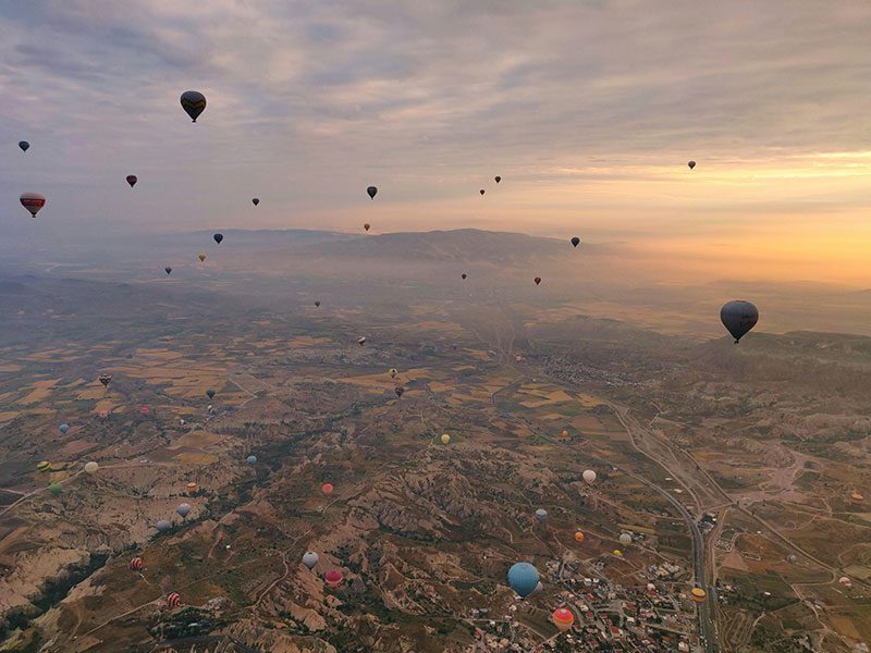 Fotografía aérea de un paisaje lleno de globos aerostáticos